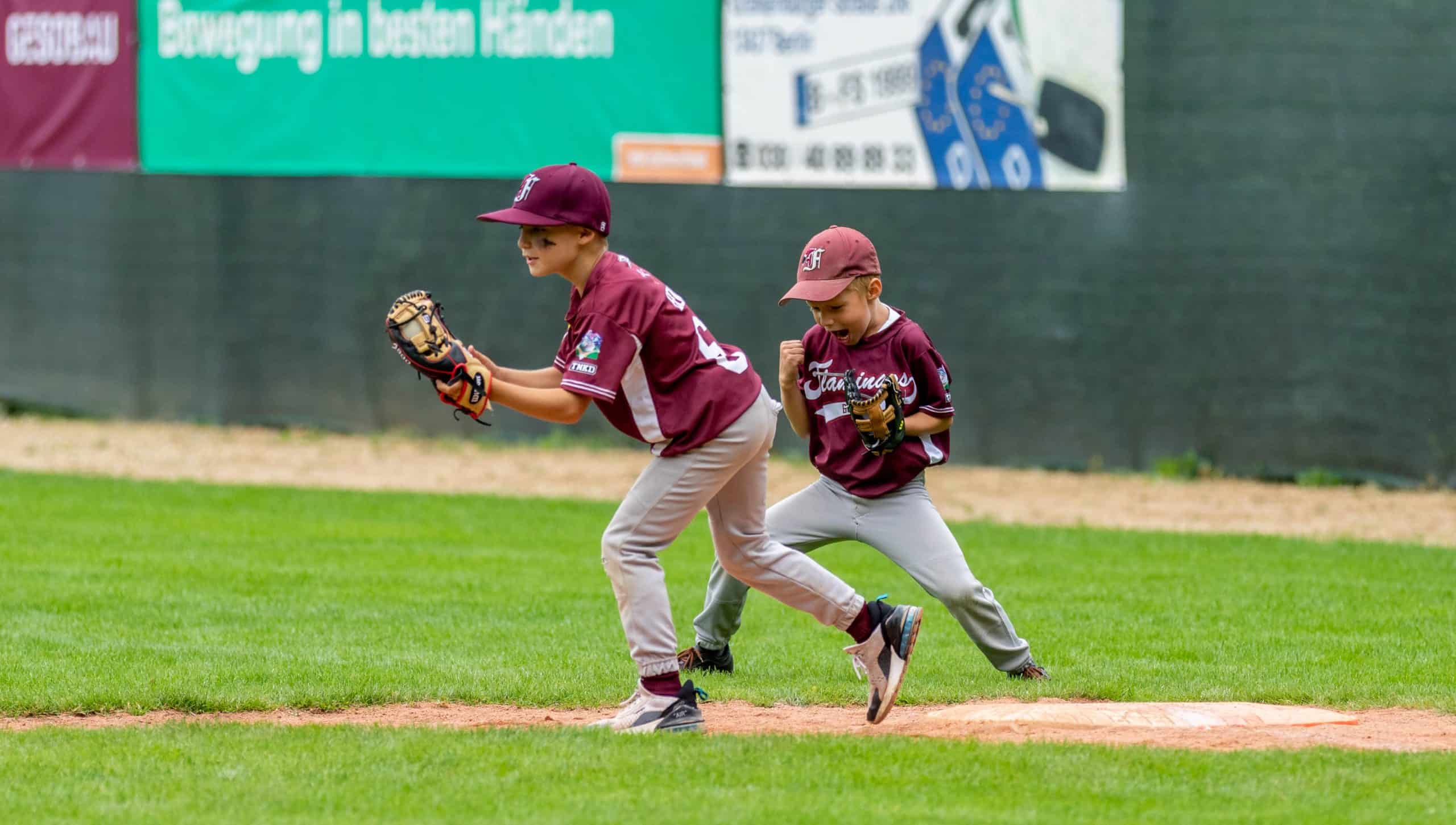 Pitcher und Baseman in Aktion versuchen einen Baseball zu fangen